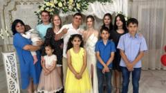Групповое семейное фото мужчин, женщин и детей на фоне белых штор