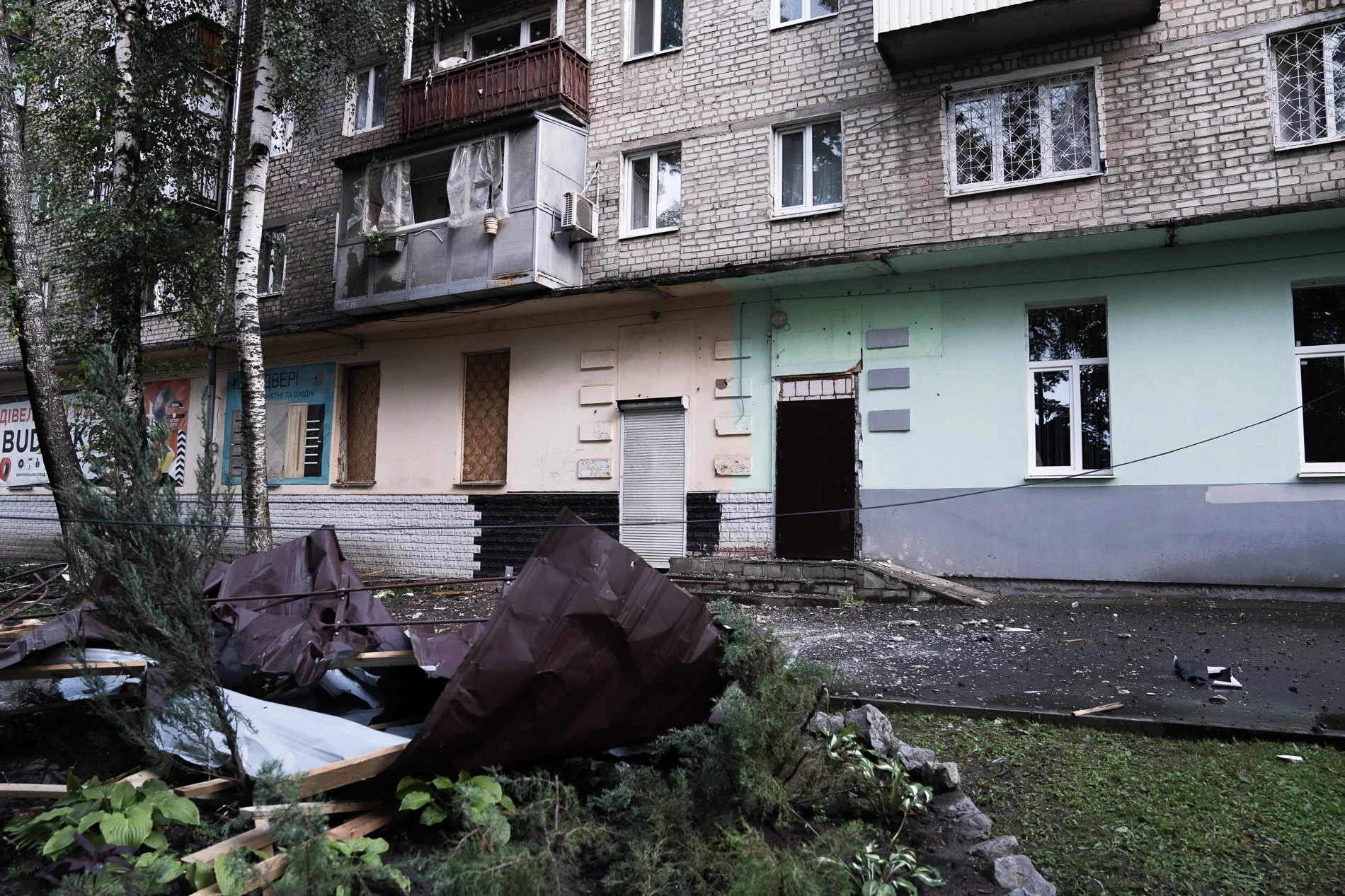 Пошкоджений житловий будинок з уламками покрівлі на землі в Харкові