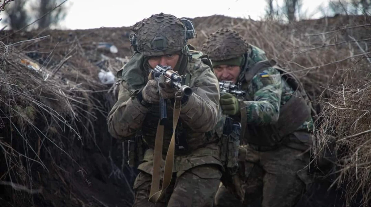 Украинские военные целятся из винтовки в траншее на фронте