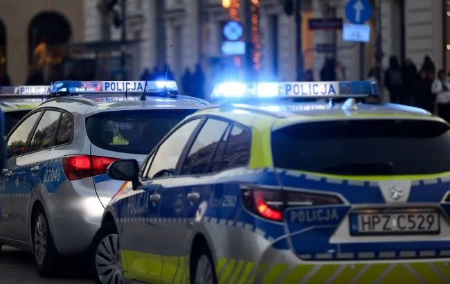 Два автомобілі польської поліції з увімкненими синіми маячками на міській вулиці