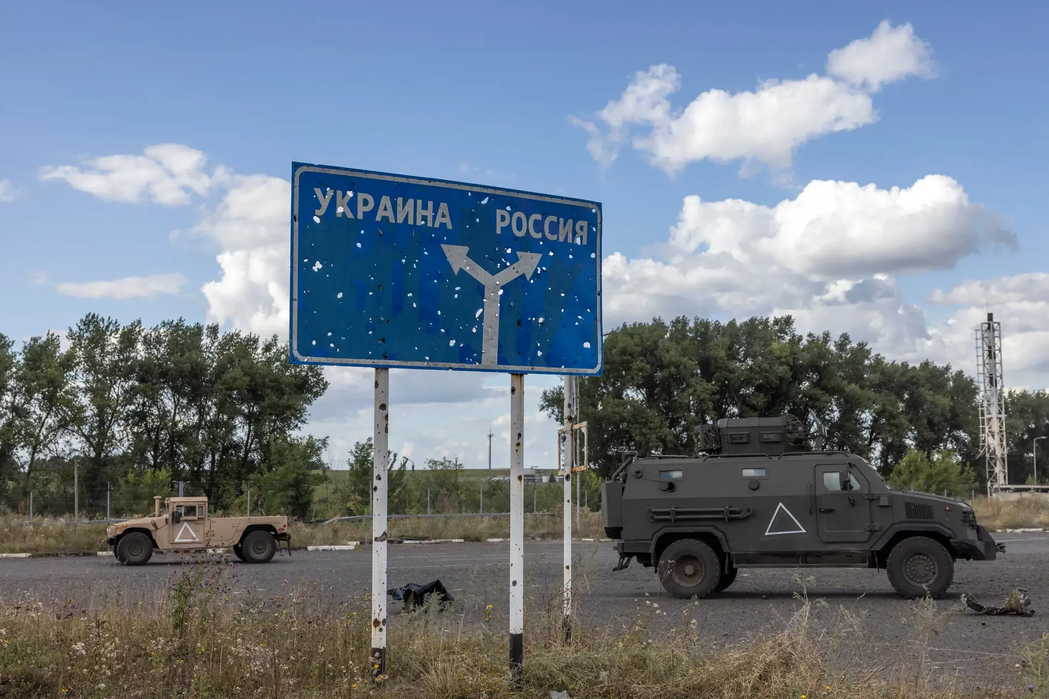 Дорожній знак кордону України та Росії з військовою технікою