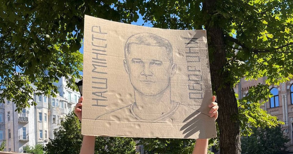 Учасник протесту тримає картонний плакат з портретом Федорова і написом Наш міністр