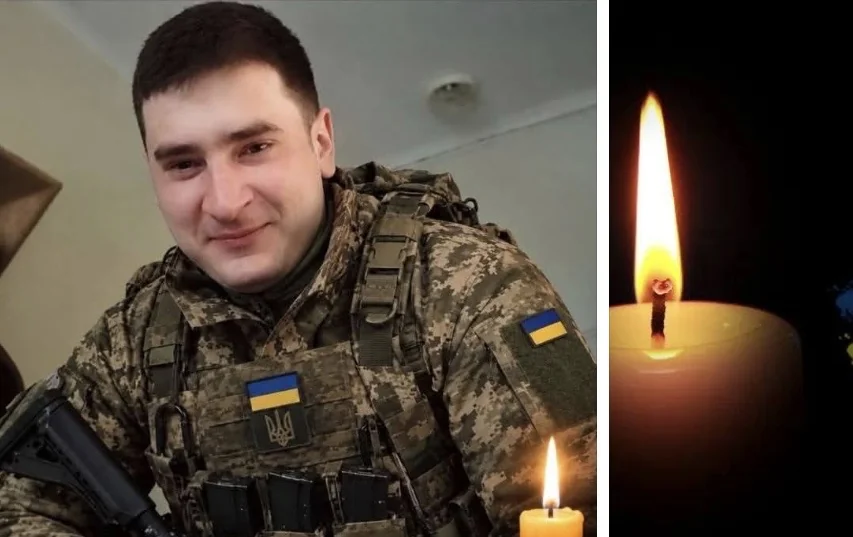 Військовий ЗСУ в піксельному камуфляжі з шевронами України та запалена свічка
