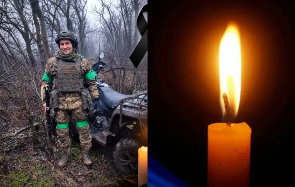 Воїн у камуфляжі біля квадроцикла в лісі та запалена поминальна свічка