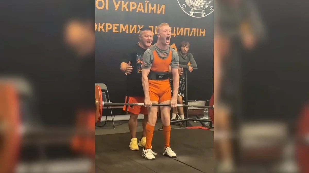 Спортсмен у помаранчевому трико виконує станову тягу на чемпіонаті України